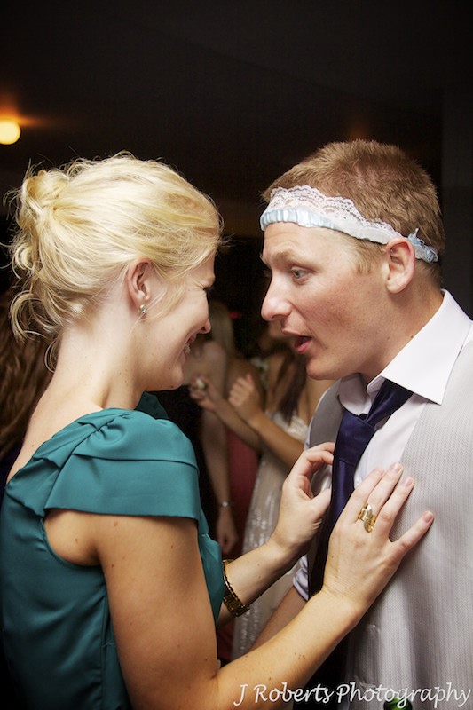Best man talking to girlfriend after claiming the garter - wedding photography sydney
